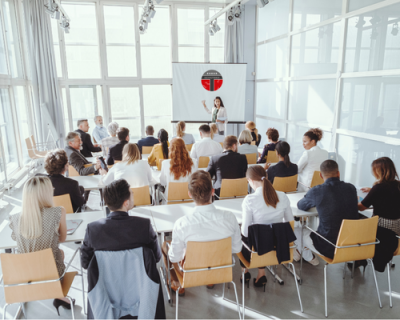 Seminarraum mit Teilnehmenden, die einem Referenten zuhören